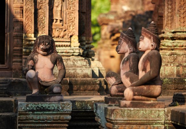 2 kneeling statues of human figures